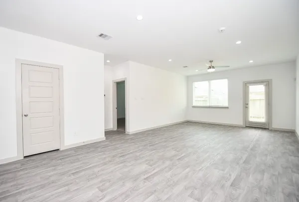 an empty room with wooden floor and windows