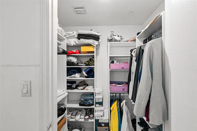 a bedroom with a bed a table and a large window