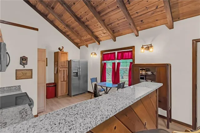 a kitchen with stainless steel appliances granite countertop a stove top oven a refrigerator a sink and dishwasher with wooden floor