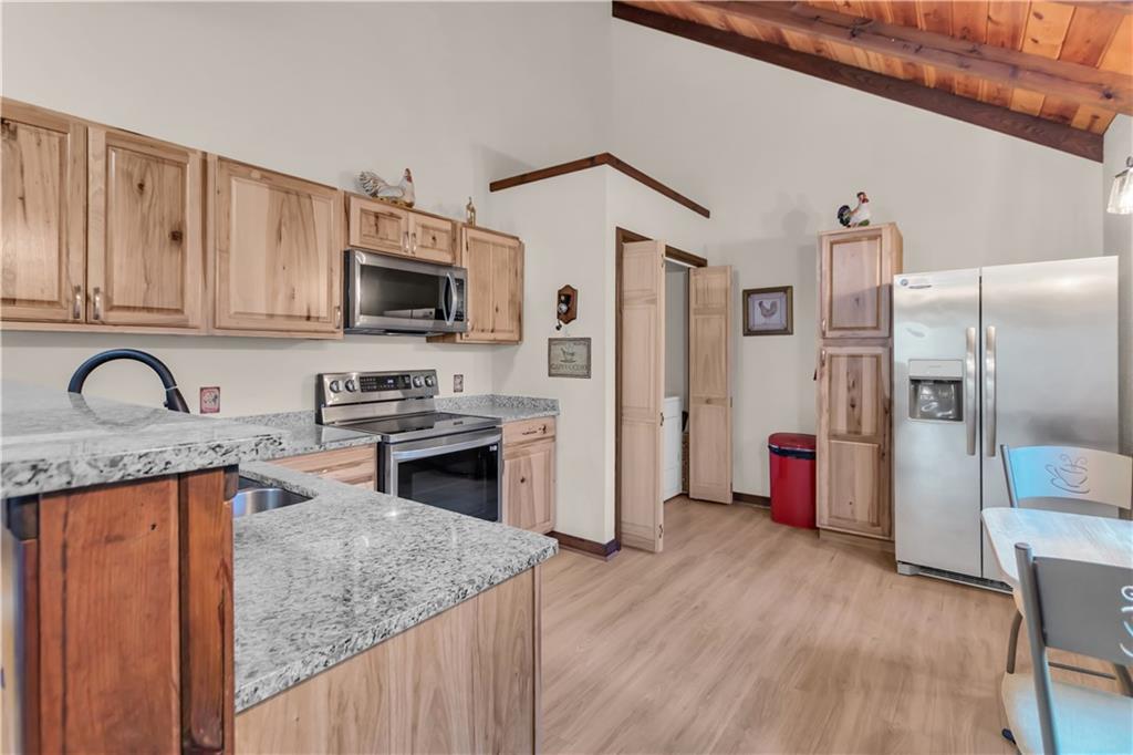 112 Old Stagecoach Road Clarkesville, GA 30523 - Photo 16 of 39 a kitchen with stainless steel appliances granite countertop a stove top oven a refrigerator a sink and dishwasher with wooden floor