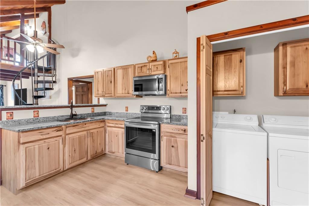 112 Old Stagecoach Road Clarkesville, GA 30523 - Photo 18 of 39 a kitchen with stainless steel appliances granite countertop a stove top oven a sink and dishwasher with wooden floor