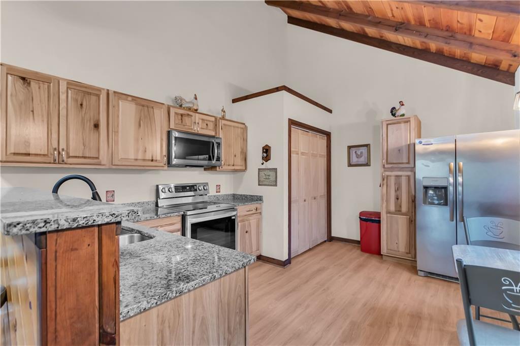 112 Old Stagecoach Road Clarkesville, GA 30523 - Photo 20 of 39 a kitchen with stainless steel appliances granite countertop a refrigerator oven a sink dishwasher and wooden cabinets with wooden floor