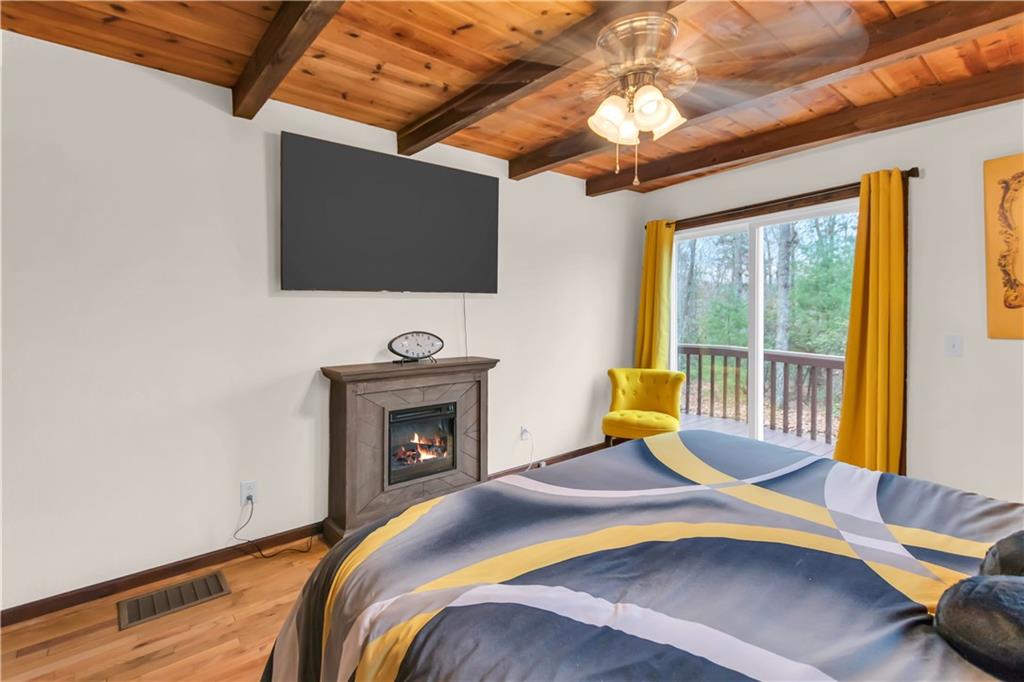 112 Old Stagecoach Road Clarkesville, GA 30523 - Photo 29 of 39 a bedroom with a bed a flat screen tv and chandelier