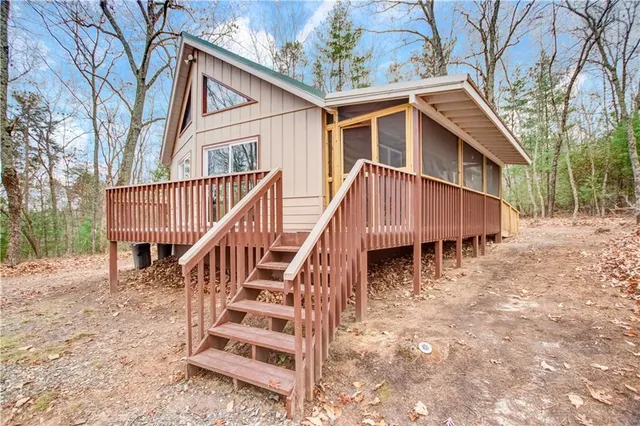 a view of a house with wooden stairs and a yard