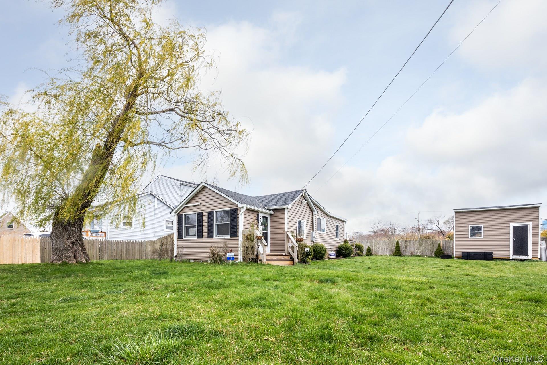 24 Blue Point Road Mastic Beach, NY 11951 - Photo 1 of 16 a view of a big house with a big yard and large trees