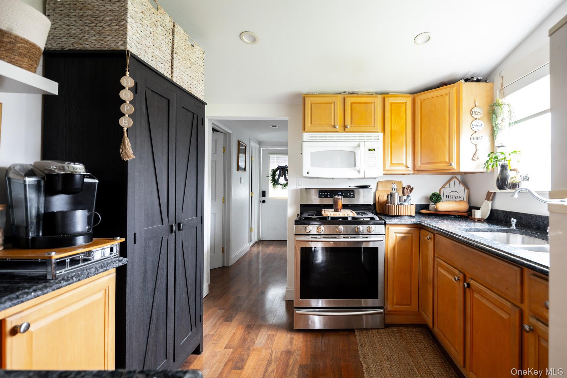 24 Blue Point Road Mastic Beach, NY 11951 - Photo 12 of 16 a kitchen with stainless steel appliances granite countertop a stove a refrigerator and a sink