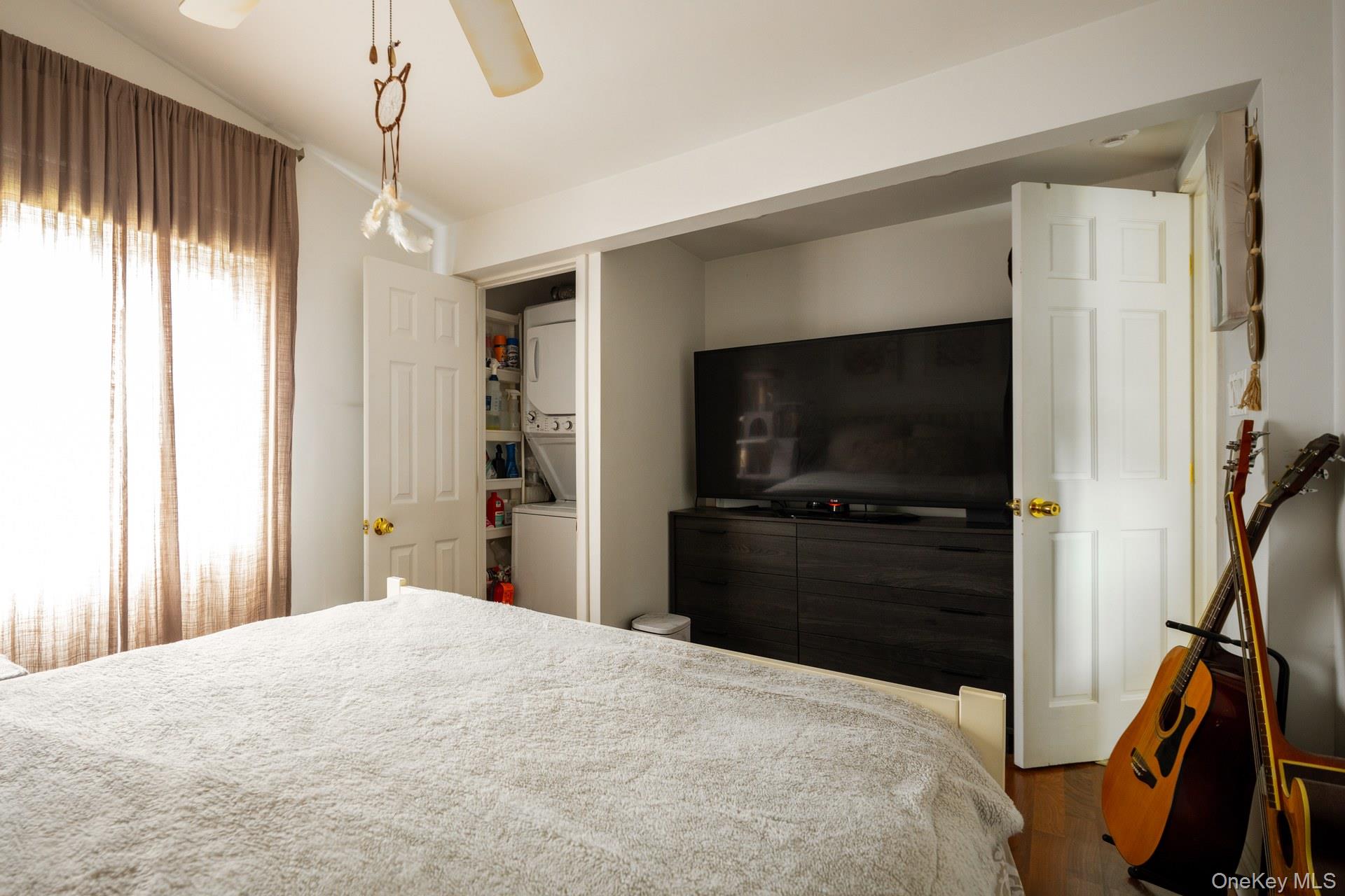 24 Blue Point Road Mastic Beach, NY 11951 - Photo 14 of 16 a bedroom with a bed and a flat tv screen on wall
