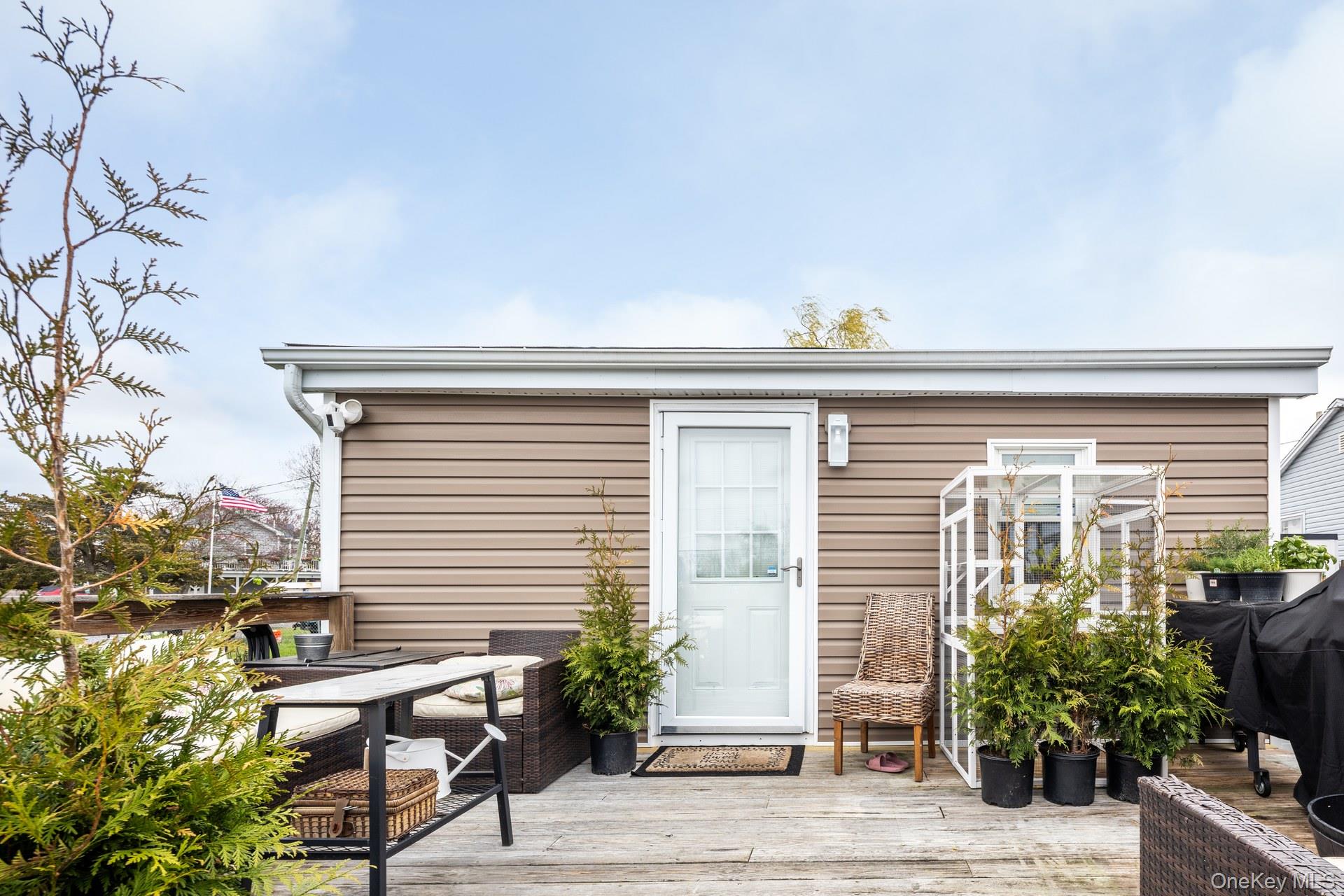 24 Blue Point Road Mastic Beach, NY 11951 - Photo 3 of 16 a view of a porch with chairs and potted plants