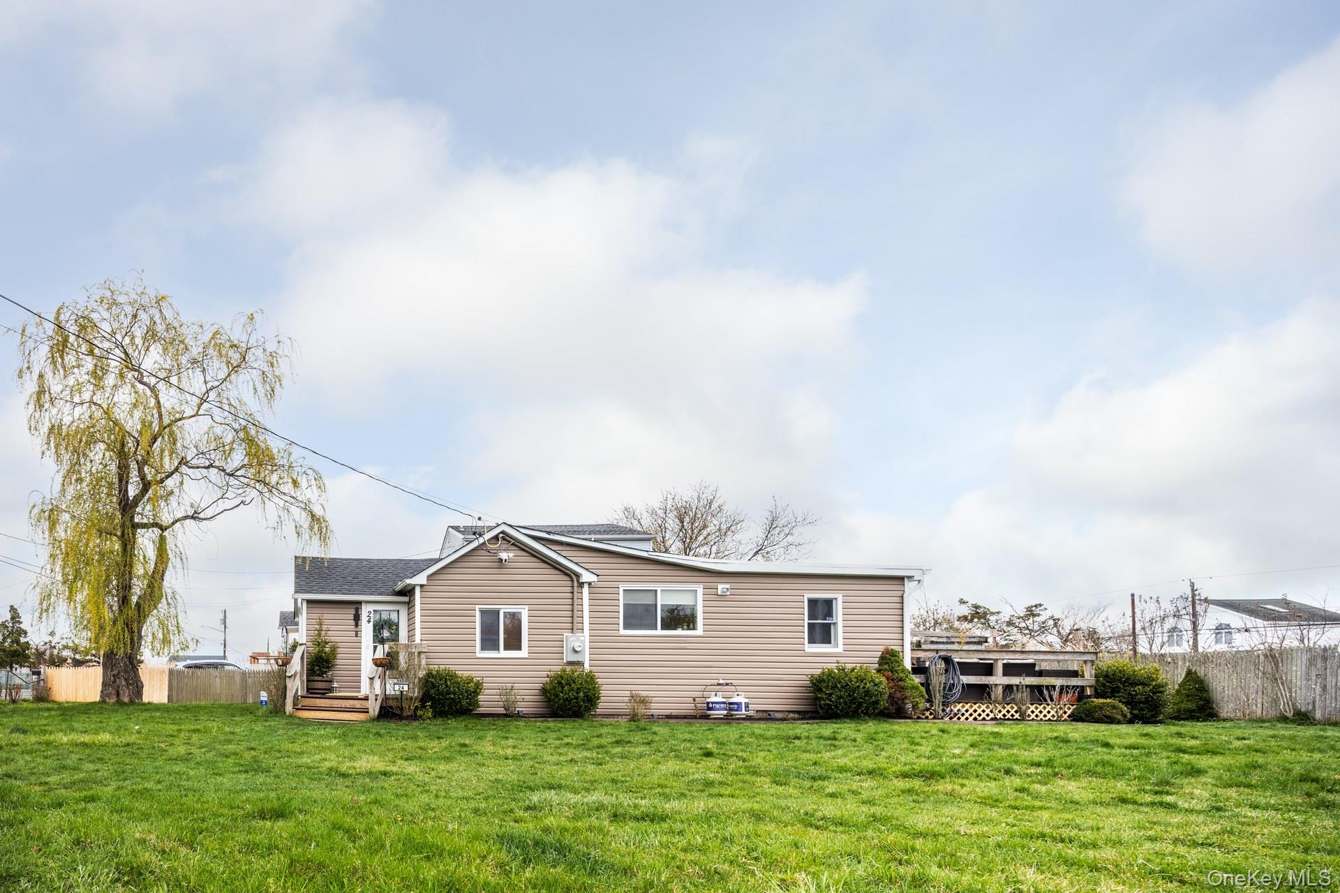 24 Blue Point Road Mastic Beach, NY 11951 - Photo 5 of 16 a front view of house with yard and green space