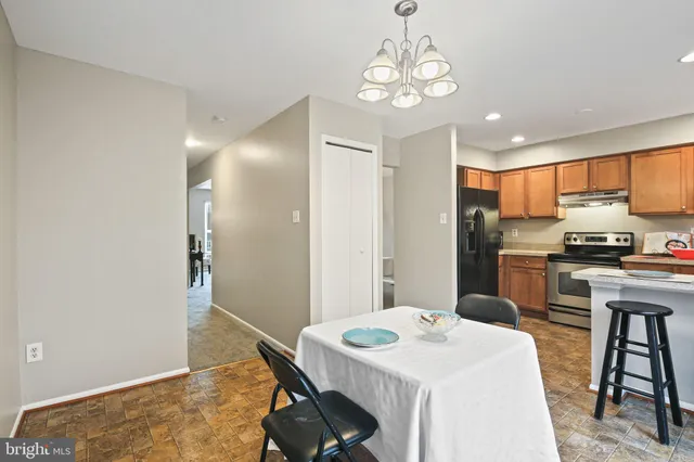 a kitchen with a refrigerator a stove a sink and a dining table