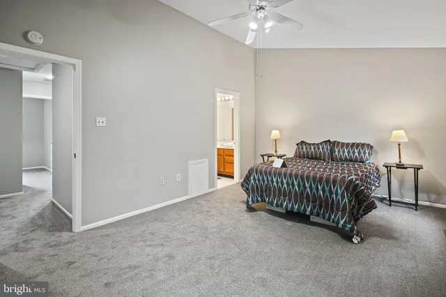 a spacious bedroom with a bed and a lamp