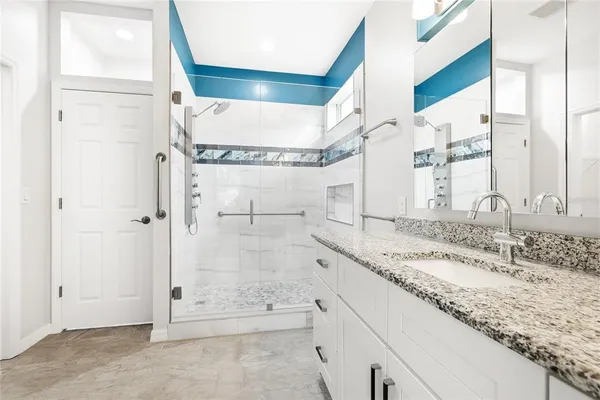 a bathroom with a granite countertop sink and a mirror