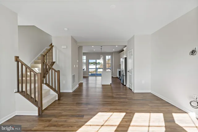 a view of interior space with wooden floor and kitchen view