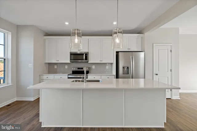 a kitchen with kitchen island white cabinets and stainless steel appliances