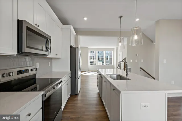 a kitchen with stainless steel appliances a stove sink microwave and cabinets