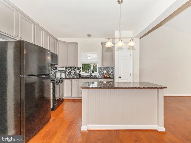 a kitchen with stainless steel appliances granite countertop a refrigerator a sink and a stove