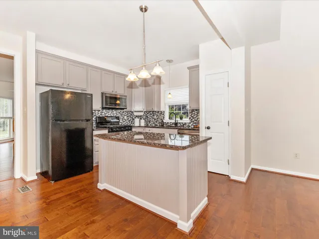 a kitchen with stainless steel appliances granite countertop a refrigerator a oven a sink and a refrigerator