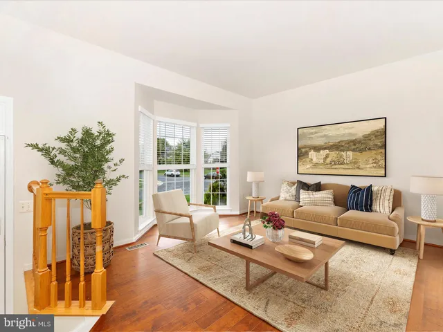 a living room with furniture potted plant and a large window