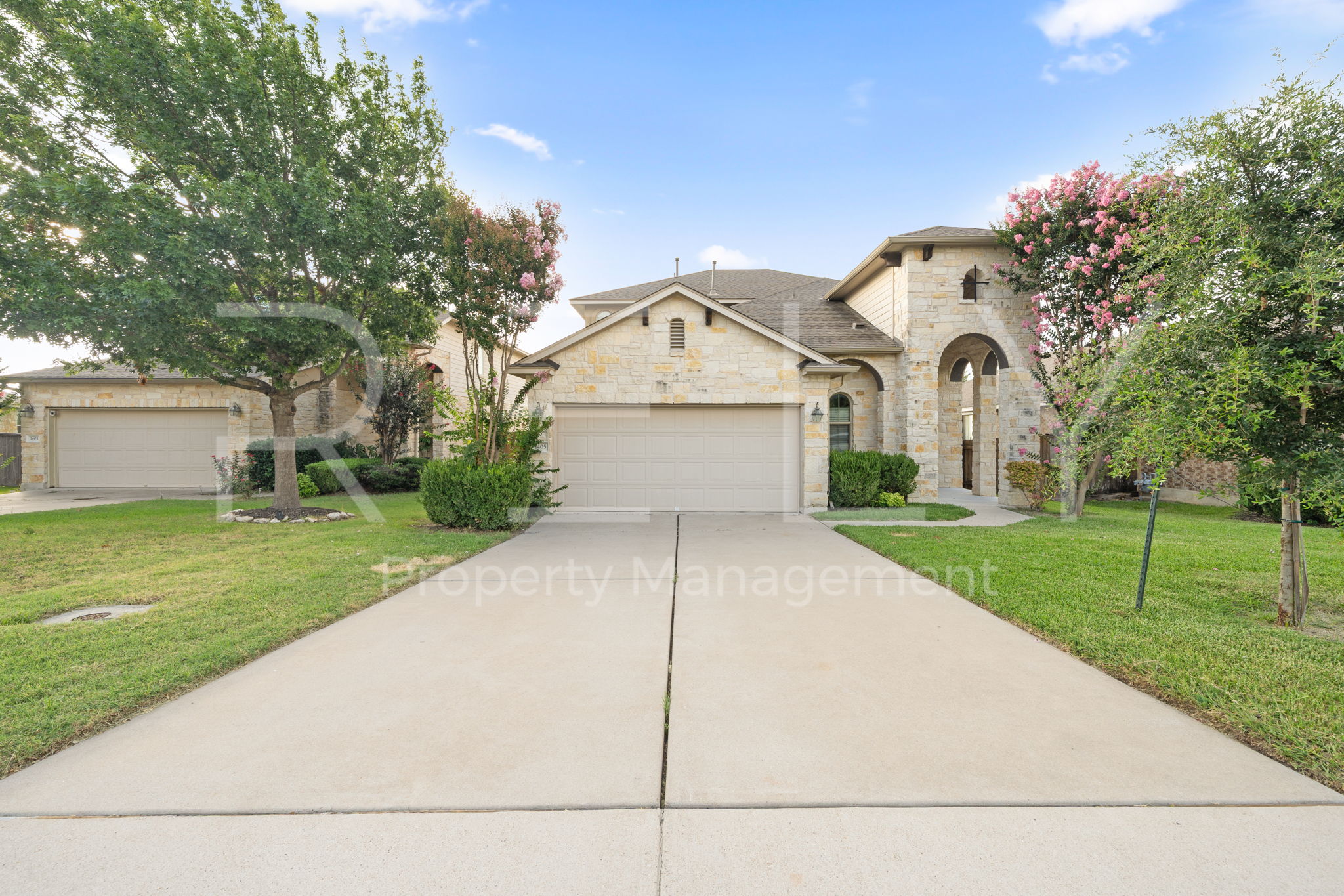 1405 Sunny Meadows Loop Georgetown, TX 78626 - Photo 1 of 40 A striking stone facade with arched entryways and a wide driveway greets visitors.