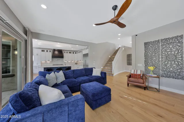 a kitchen with stainless steel appliances kitchen island granite countertop a dining table chairs and a refrigerator