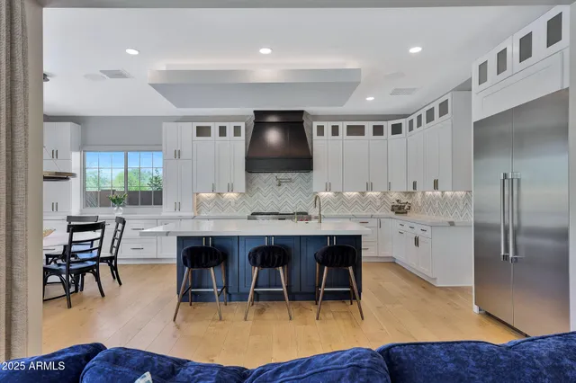 a open kitchen with stainless steel appliances granite countertop a table chairs and a stove