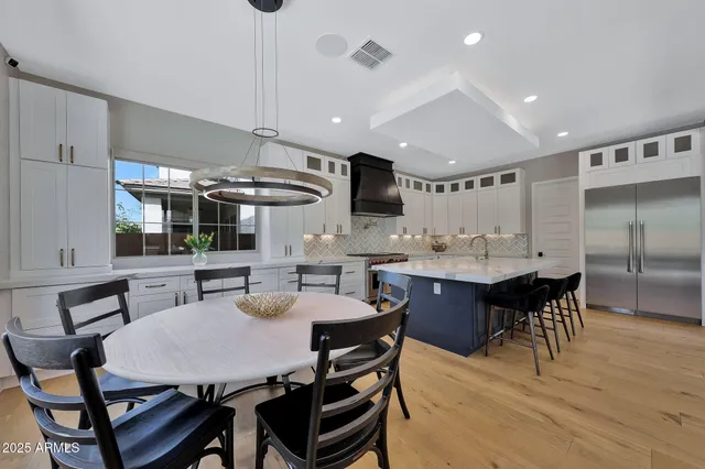 a kitchen with stainless steel appliances granite countertop a sink a stove and a refrigerator
