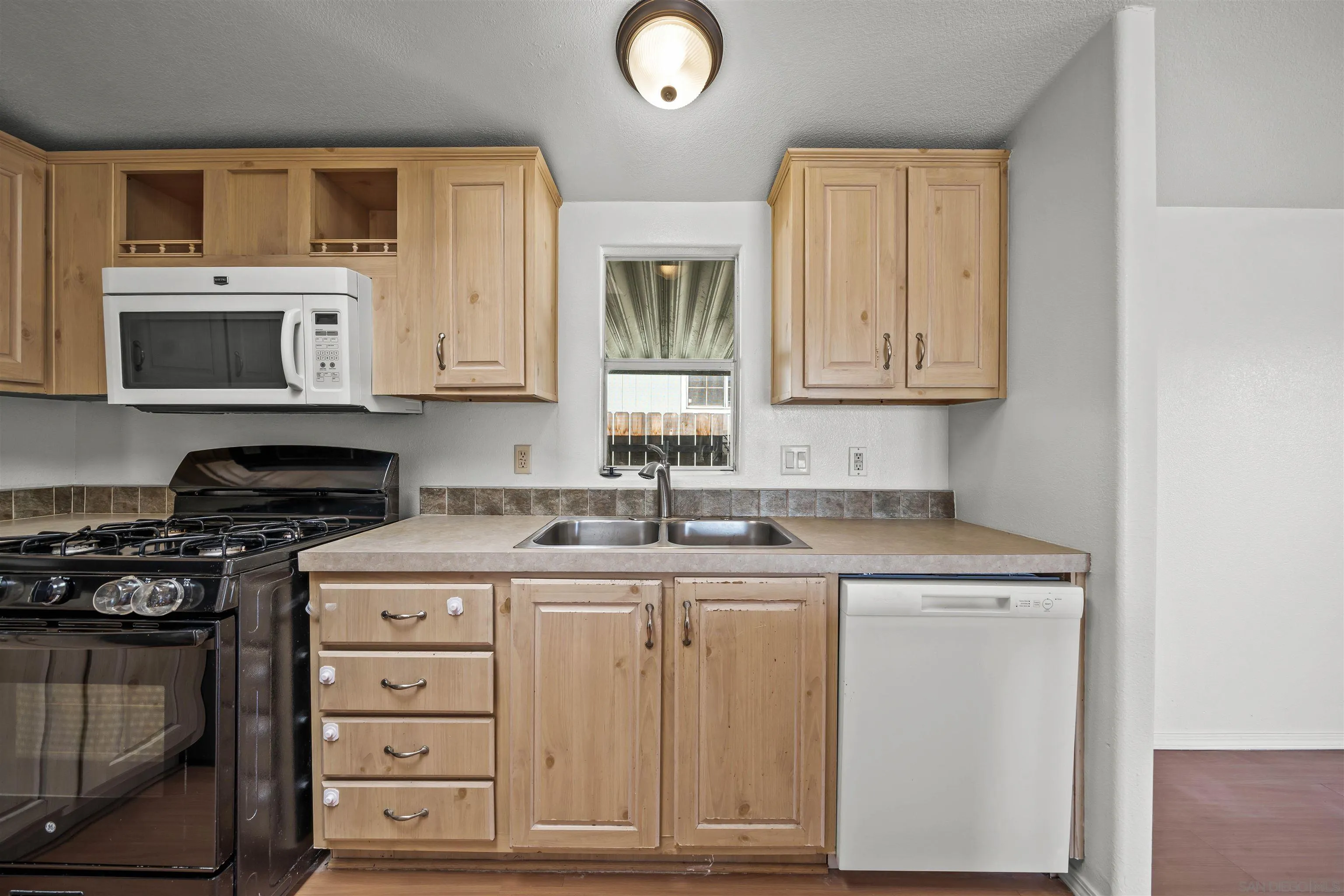 9902 Jamacha Boulevard, Unit 13 Spring Valley, CA 91977 - Photo 12 of 32 a kitchen with stainless steel appliances granite countertop a sink stove and microwave