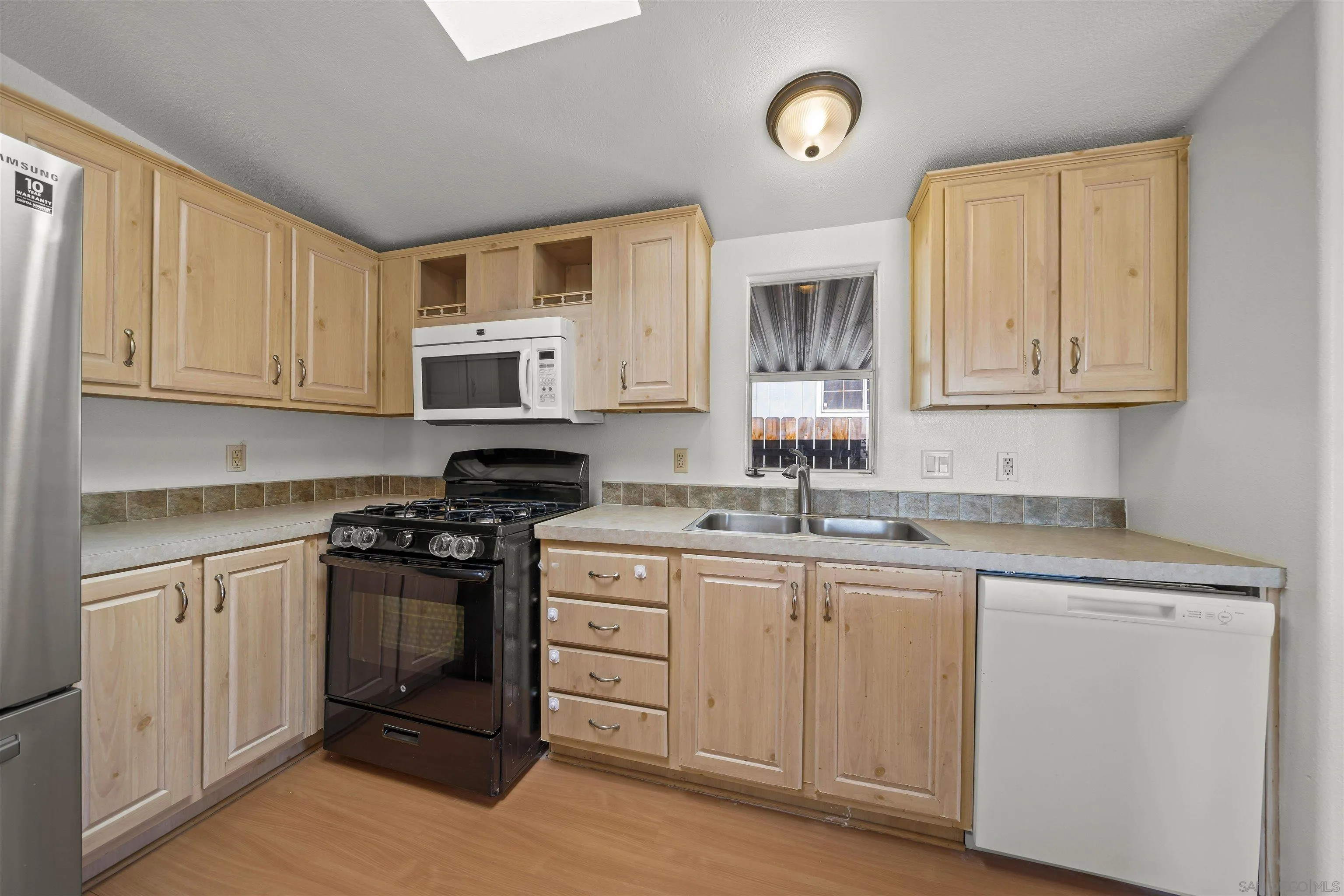 9902 Jamacha Boulevard, Unit 13 Spring Valley, CA 91977 - Photo 13 of 32 a kitchen with granite countertop white cabinets and stainless steel appliances
