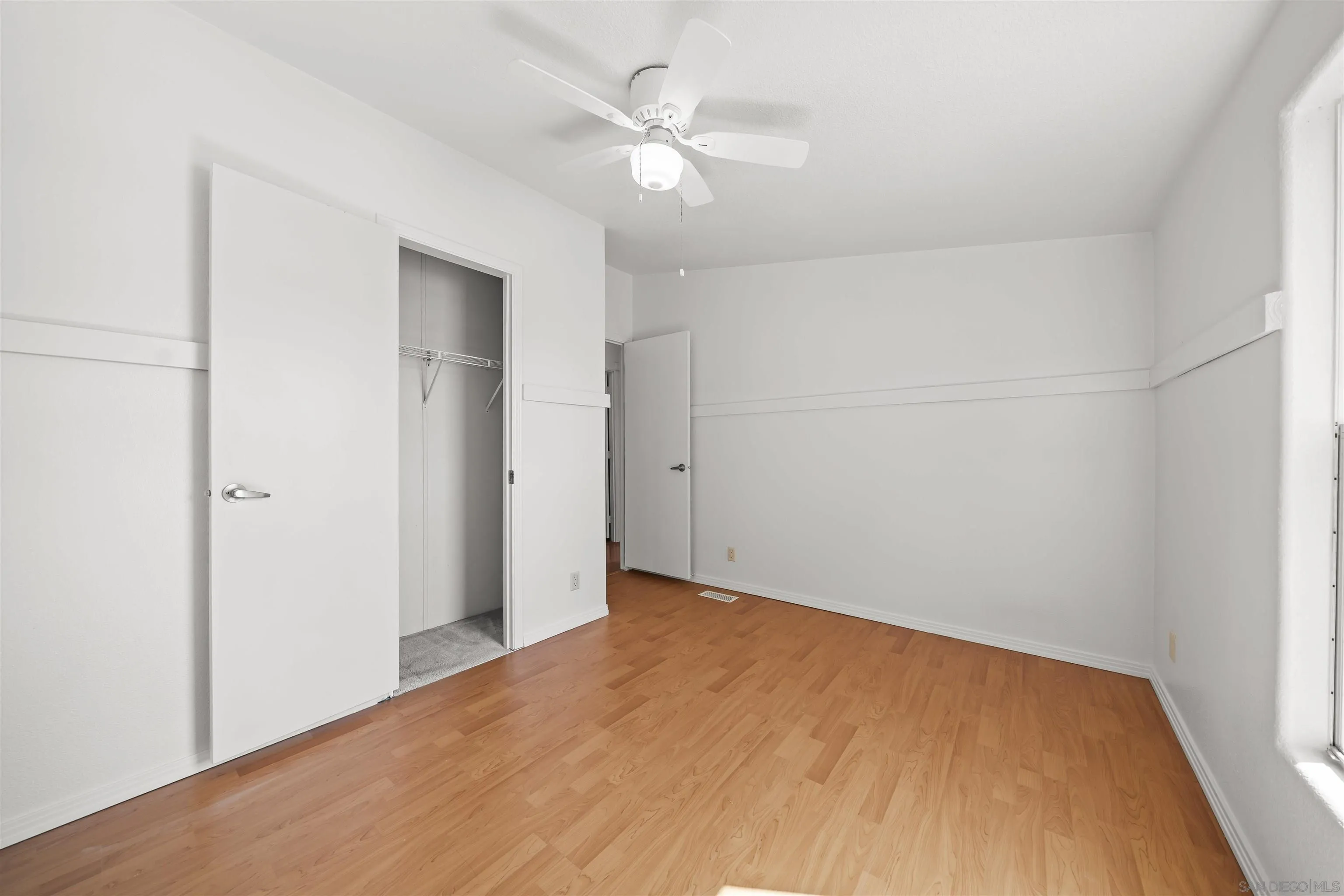 9902 Jamacha Boulevard, Unit 13 Spring Valley, CA 91977 - Photo 22 of 32 an empty room with a ceiling fan and a window