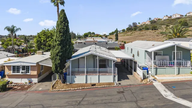 a front view of a house with a garden and mountain view