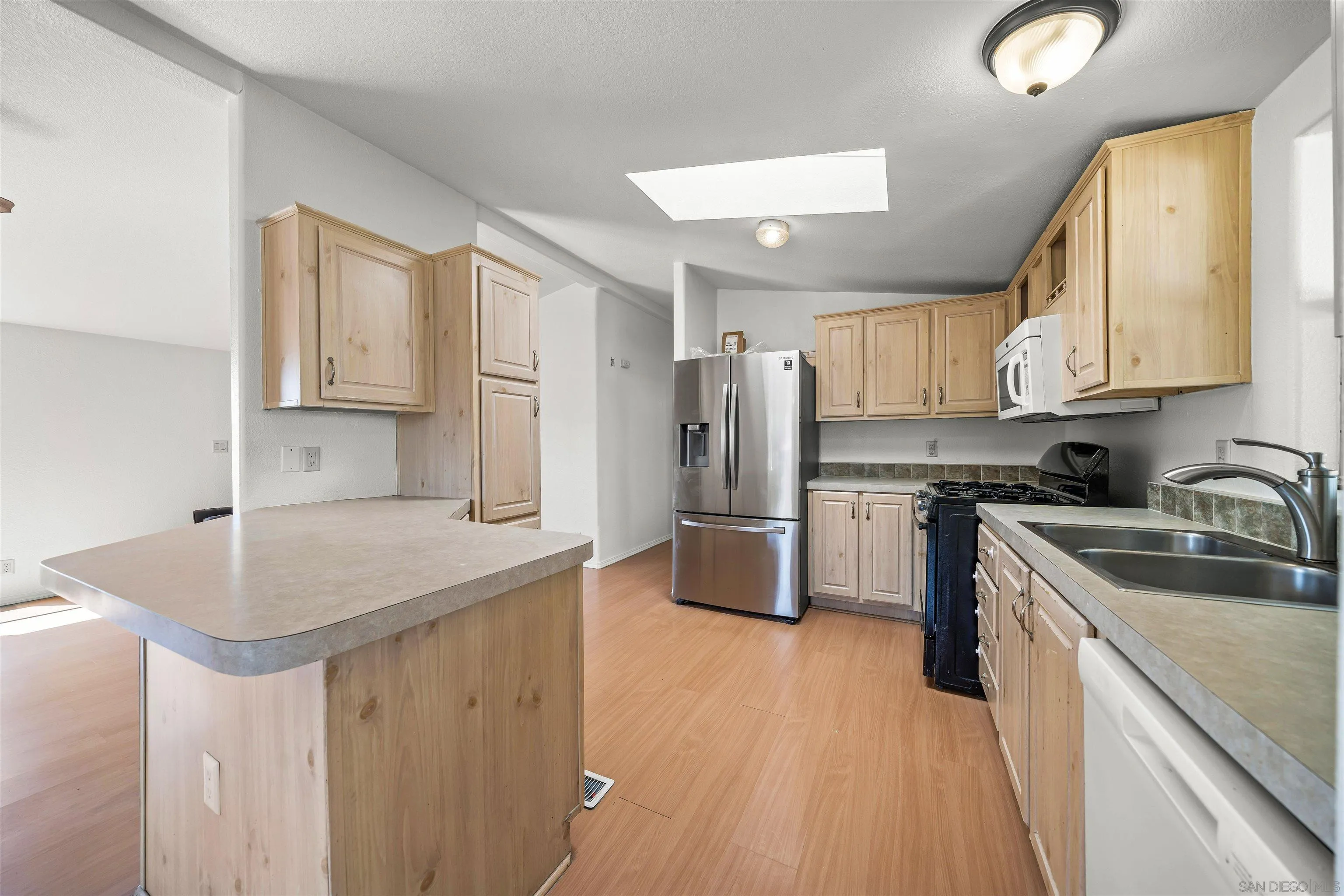 9902 Jamacha Boulevard, Unit 13 Spring Valley, CA 91977 - Photo 10 of 32 a kitchen that has a sink cabinets counter space and stainless steel appliances