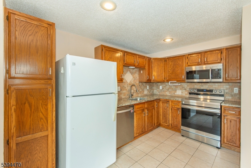 8 Constitution Way Franklin, NJ 07416 - Photo 12 of 26 a white refrigerator freezer sitting inside of a kitchen
