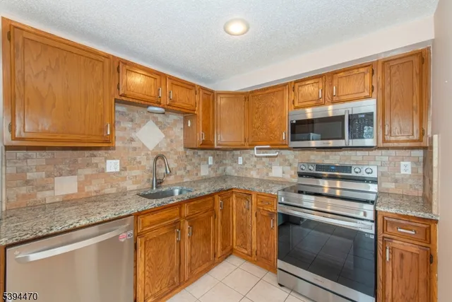a kitchen with stainless steel appliances granite countertop a sink stove and microwave