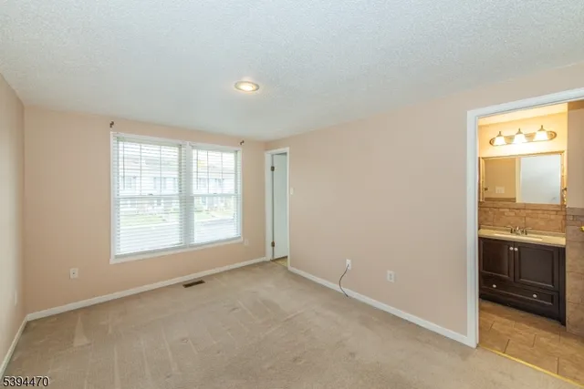 an empty room with a fireplace and windows