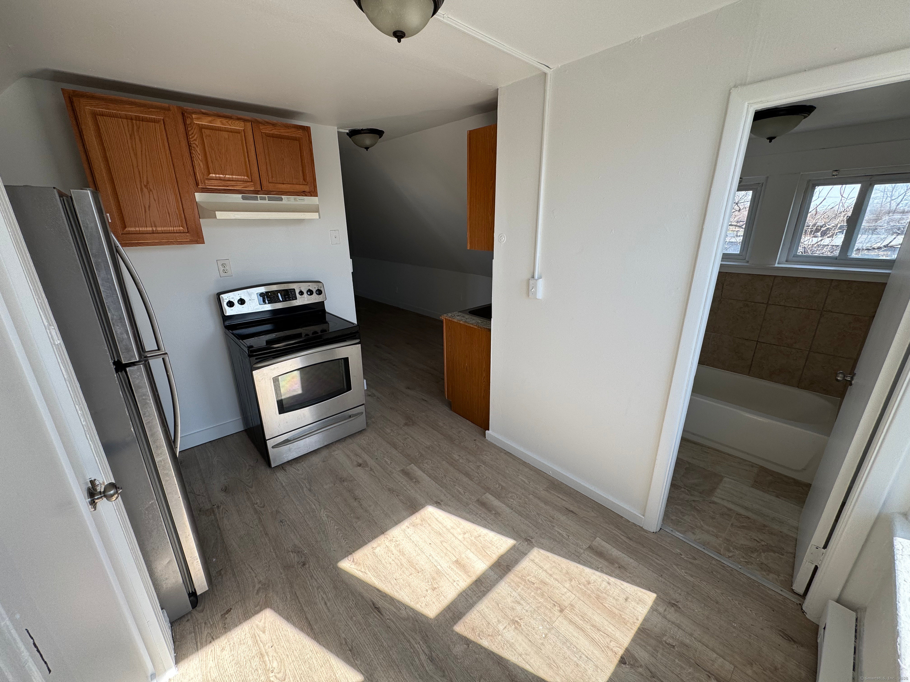 a kitchen with wooden floor and electronic appliances