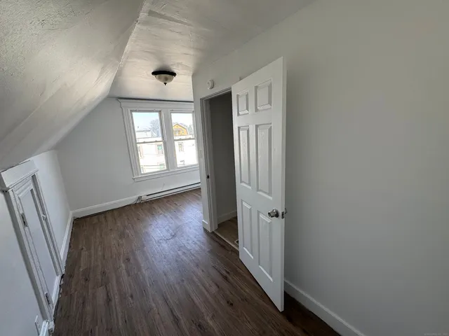 an empty room with wooden floor and a window
