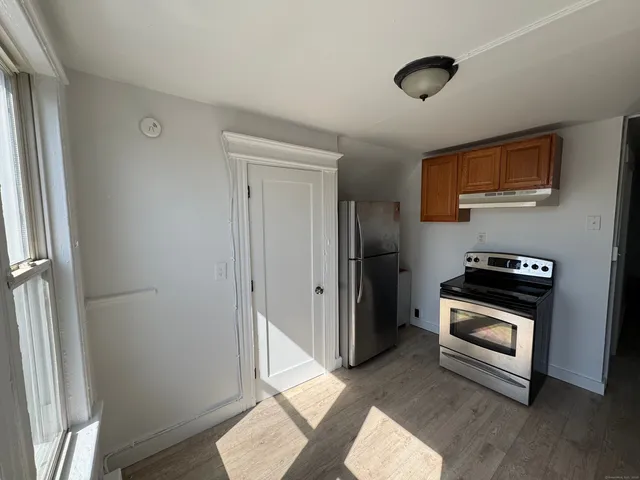 a kitchen with a refrigerator and a stove top oven