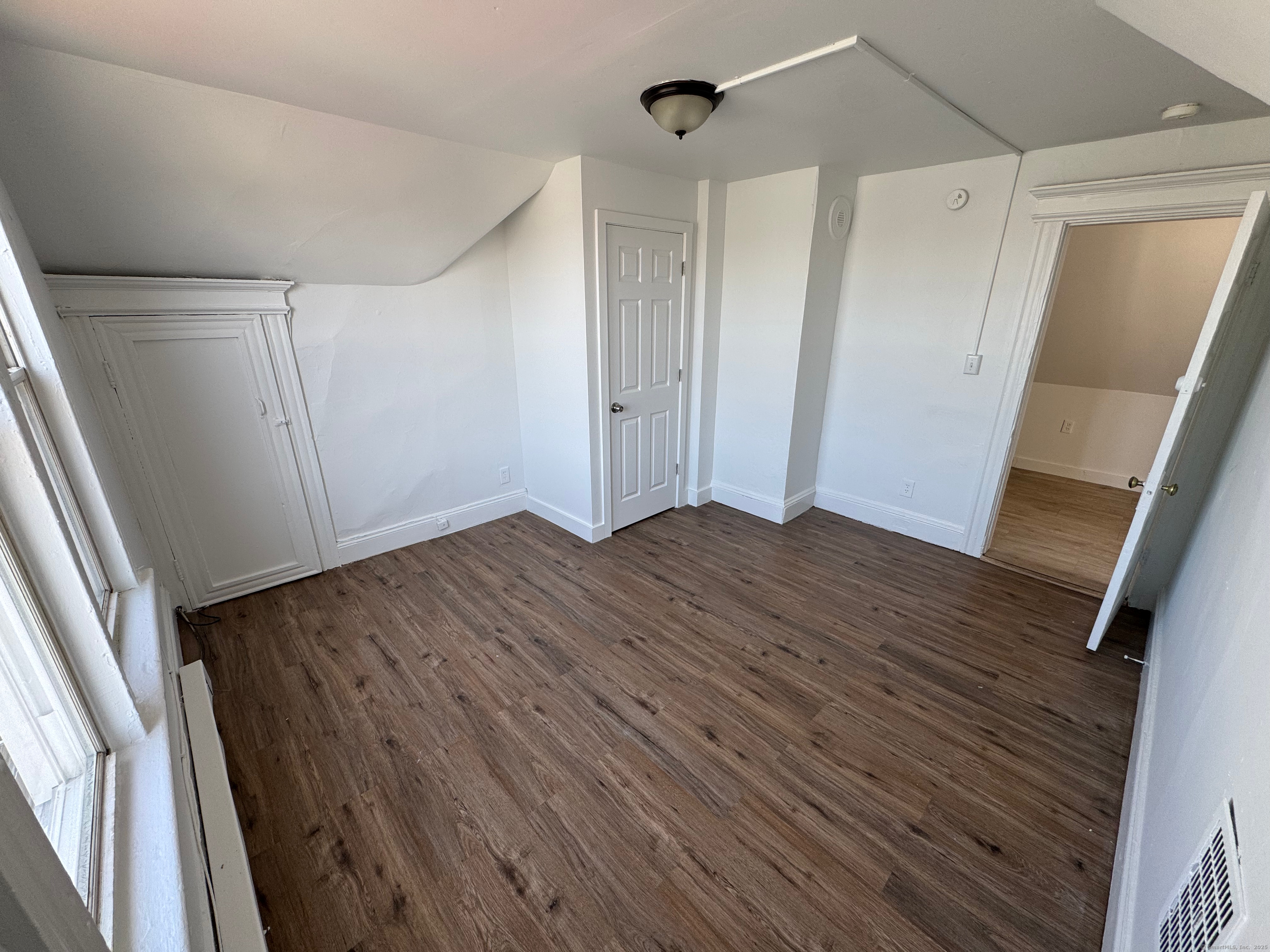 10 Beatrice Street, Unit 3 Bridgeport, CT 06607 - Photo 8 of 12 a view of an empty room with wooden floor and a window