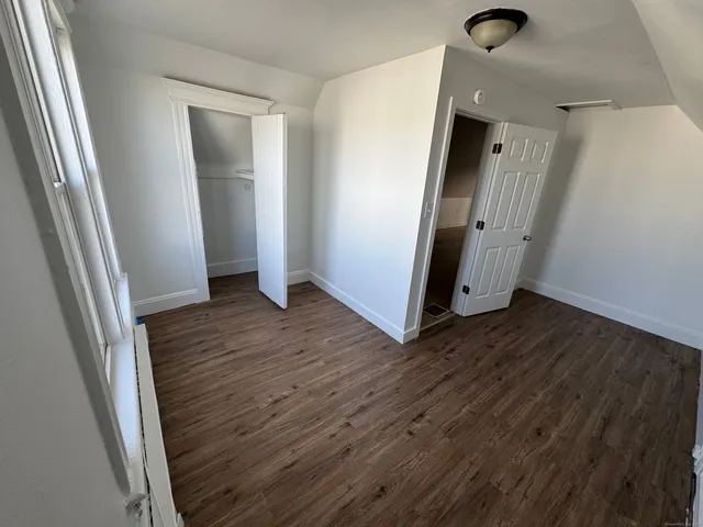 an empty room with wooden floor and entrance