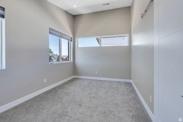 7045 South 300 East Midvale, UT 84047 - Photo 29 of 49 Room featuring light-toned walls, gray carpet flooring, and multiple windows