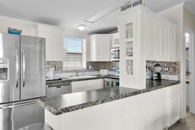 a kitchen with stainless steel appliances granite countertop a sink a stove and a refrigerator