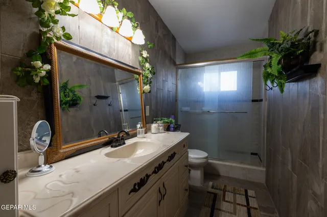 a bathroom with a sink a toilet and a mirror