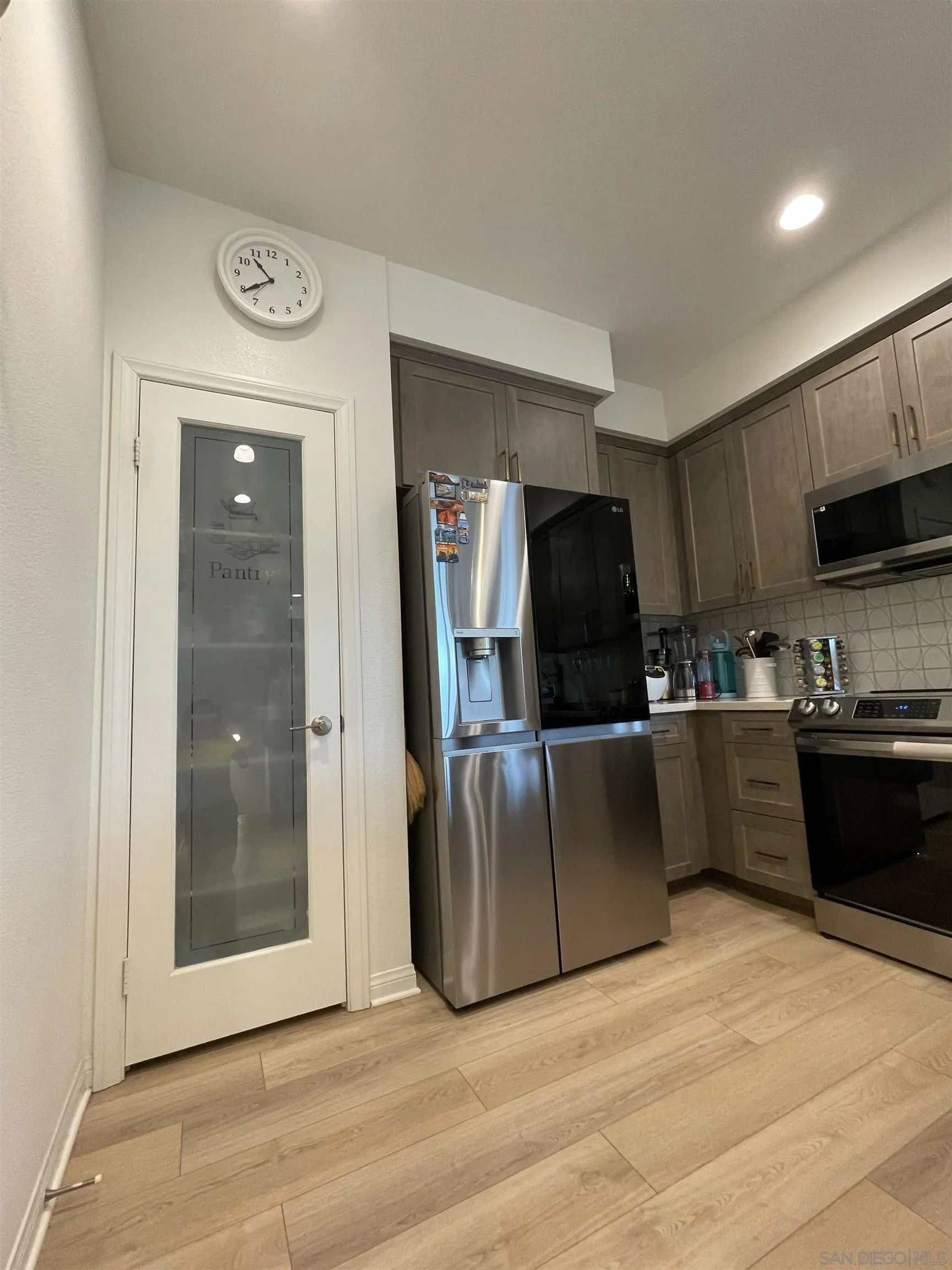 2708 Juniper Berry Street Spring Valley, CA 91977 - Photo 25 of 39 a kitchen with stainless steel appliances granite countertop a refrigerator a stove top oven and a sink with wooden floor