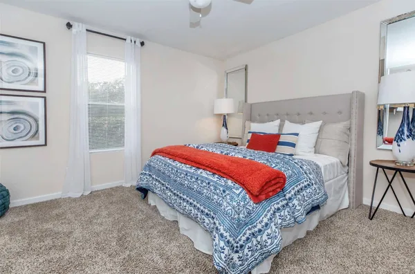 a bedroom with a bed lamp and window