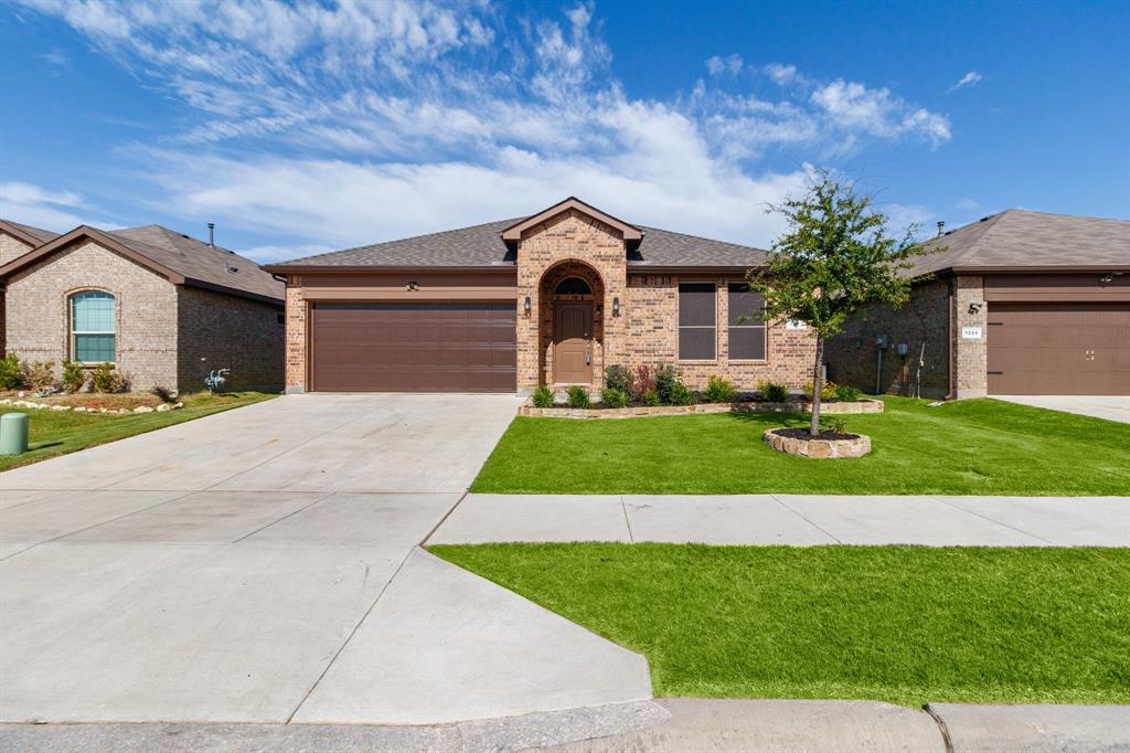 a front view of a house with a yard and garage