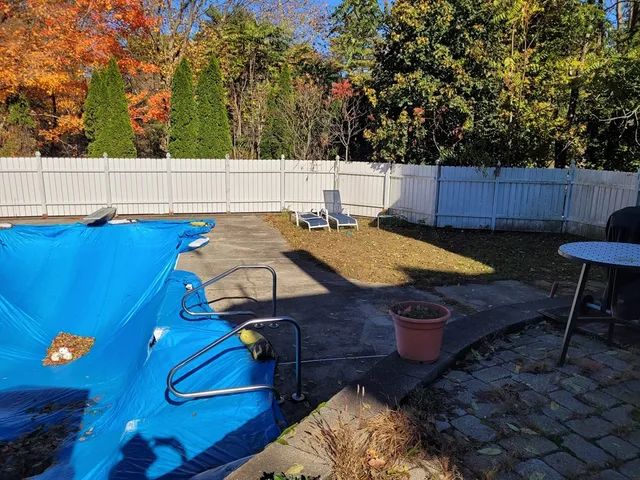 a view of a backyard with chairs and a fire pit