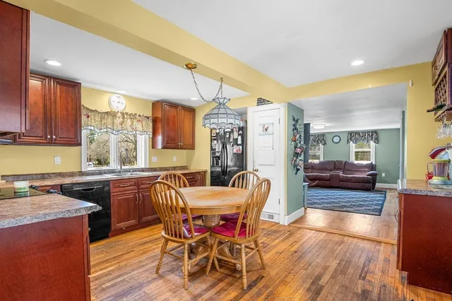 a view of a dining room with furniture a chandelier and wooden floor