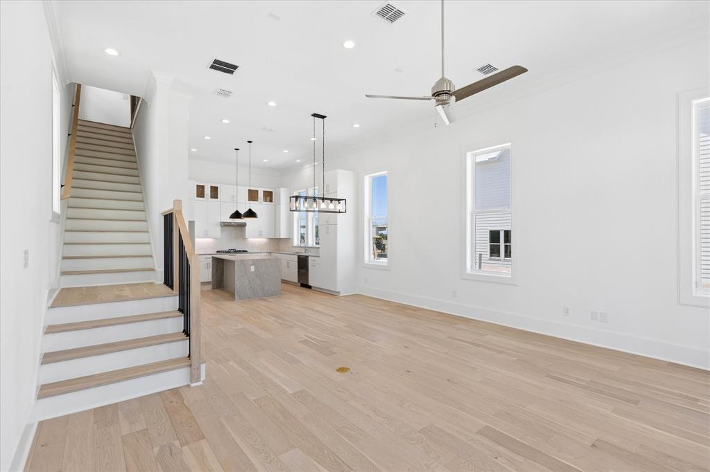 1362 East Crosby Road Carrollton, TX 75006 - Photo 8 of 22 Open-concept living space featuring light wood-finish flooring, white walls, and a contemporary ceiling fan