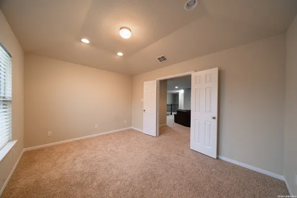 an empty room with an entryway and closet