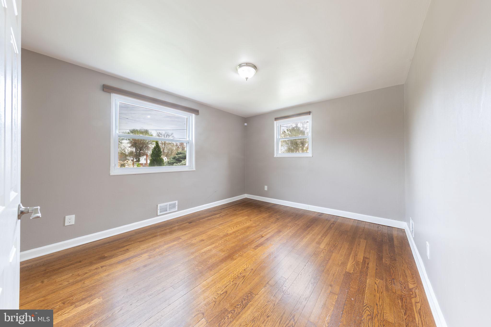 12112 Atherton Drive Silver Spring, MD 20902 - Photo 25 of 32 an empty room with wooden floor and windows
